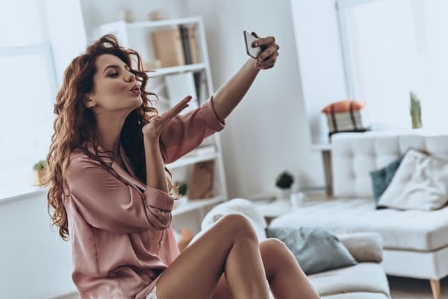a beautiful curly woman is talking a selfie at home