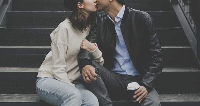 a couple kissing while sitting on stairs