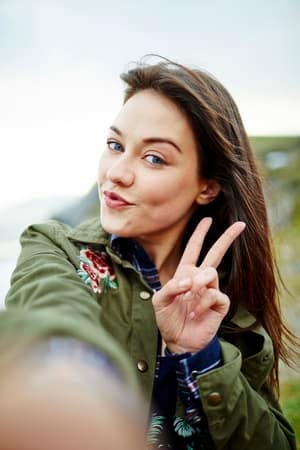 a young girl taking a selfie outdoors