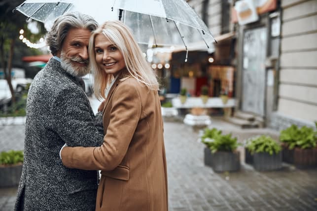 a mature couple having a romantic date under an umbrella