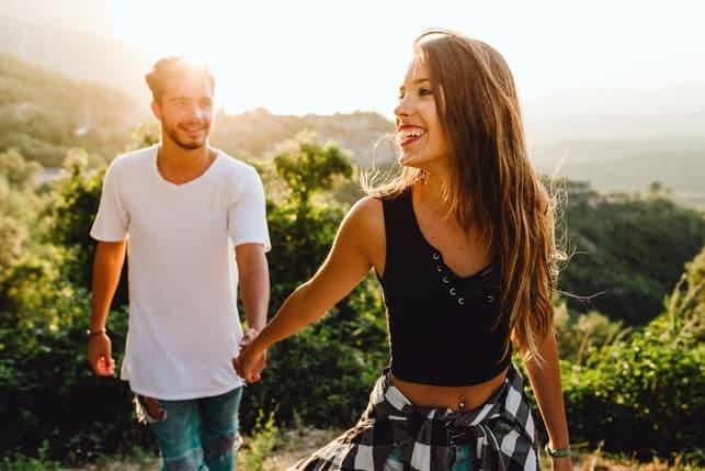 a happy couple going for a walk in the forest