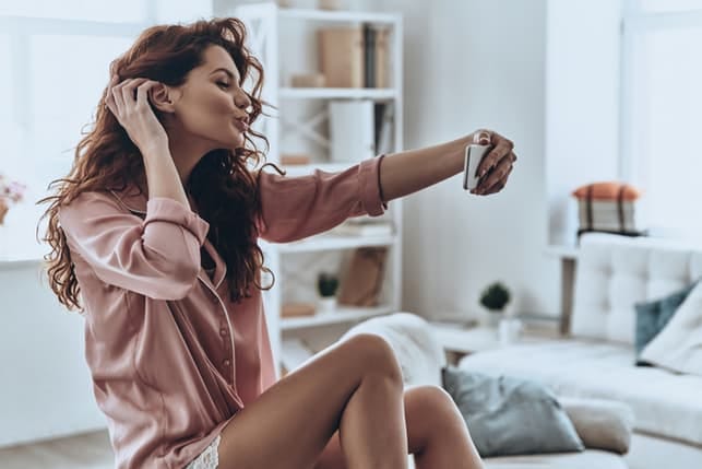 an attractive woman is taking selfies at home