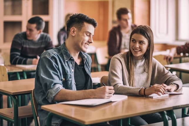a young couple flirting in a classroom