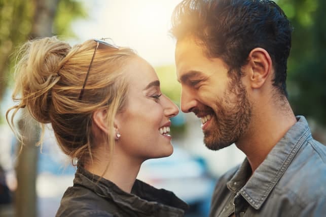a portrait of a beautiful couple smiling at each other