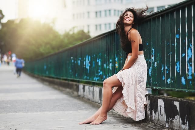 an attractive woman posing on a bridge outside