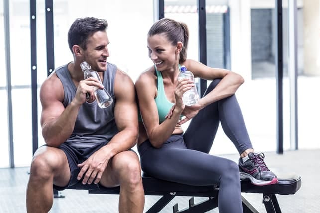 a sporty couple drinking water